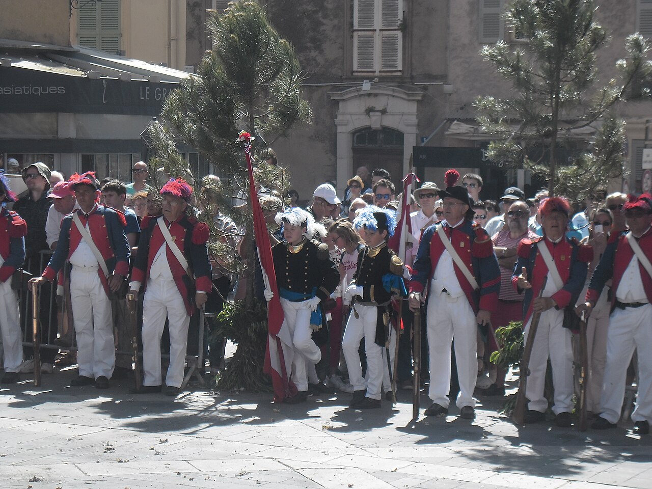 Des bravadeurs en tenue traditionnelle rassemblés sur une place de Saint-Tropez