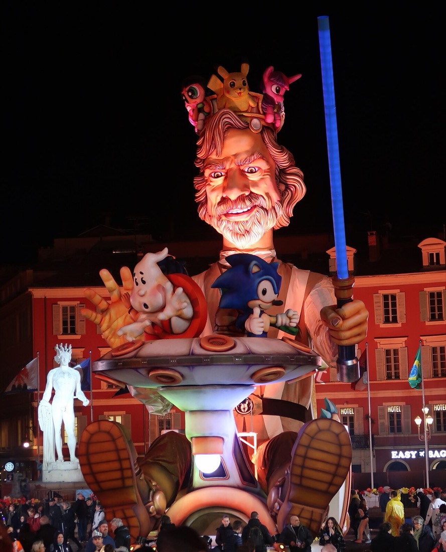 Le char du Roi du Carnaval de Nice, une tête géante souriante éclairée de nuit