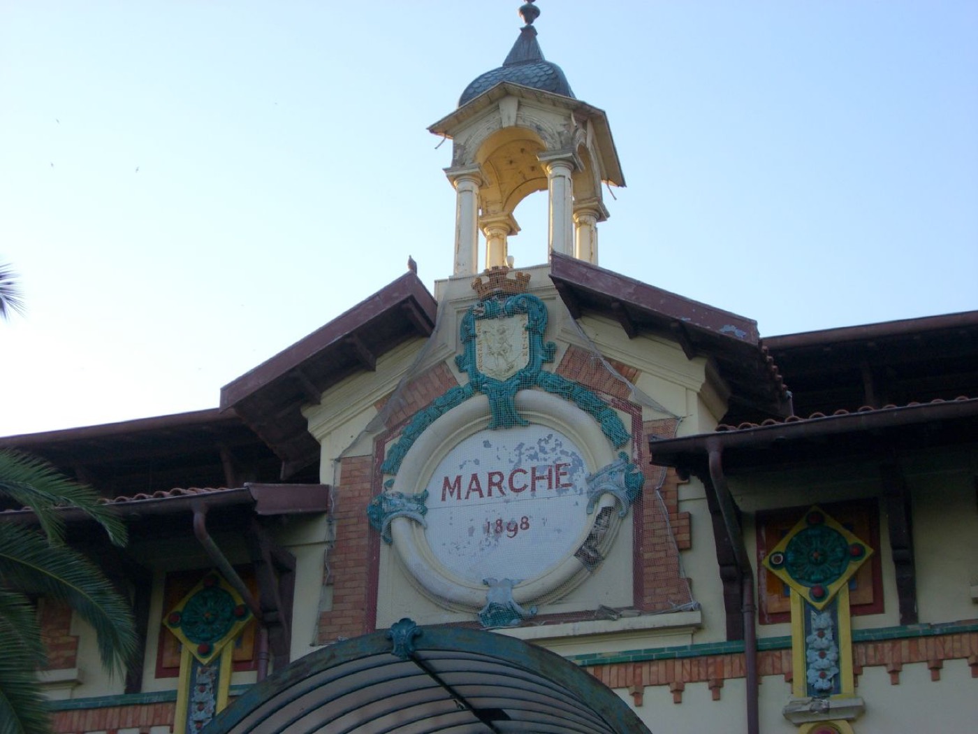 Le fronton « Marché 1898 » de la halle de Menton, entre briques et céramiques colorées
