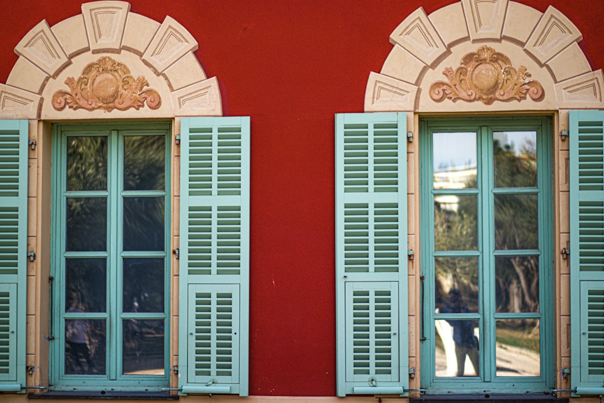 Façade rouge aux volets bleu pâle de la villa du musée Matisse, à Cimiez