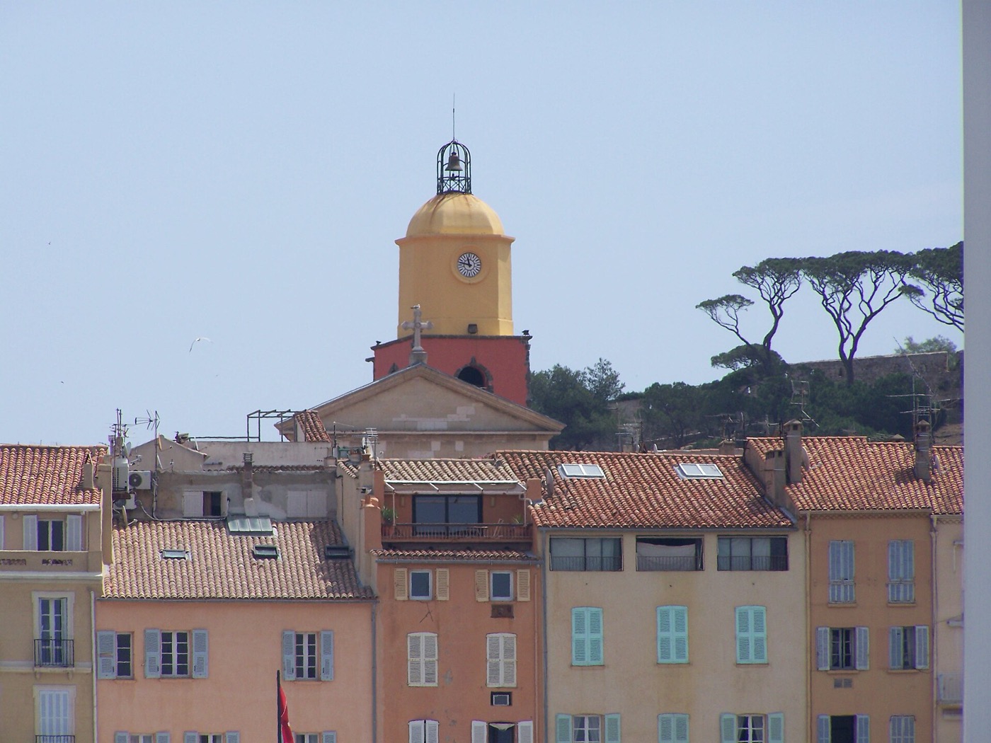Le clocher orangé de l'église de Saint-Tropez au-dessus des toits du village