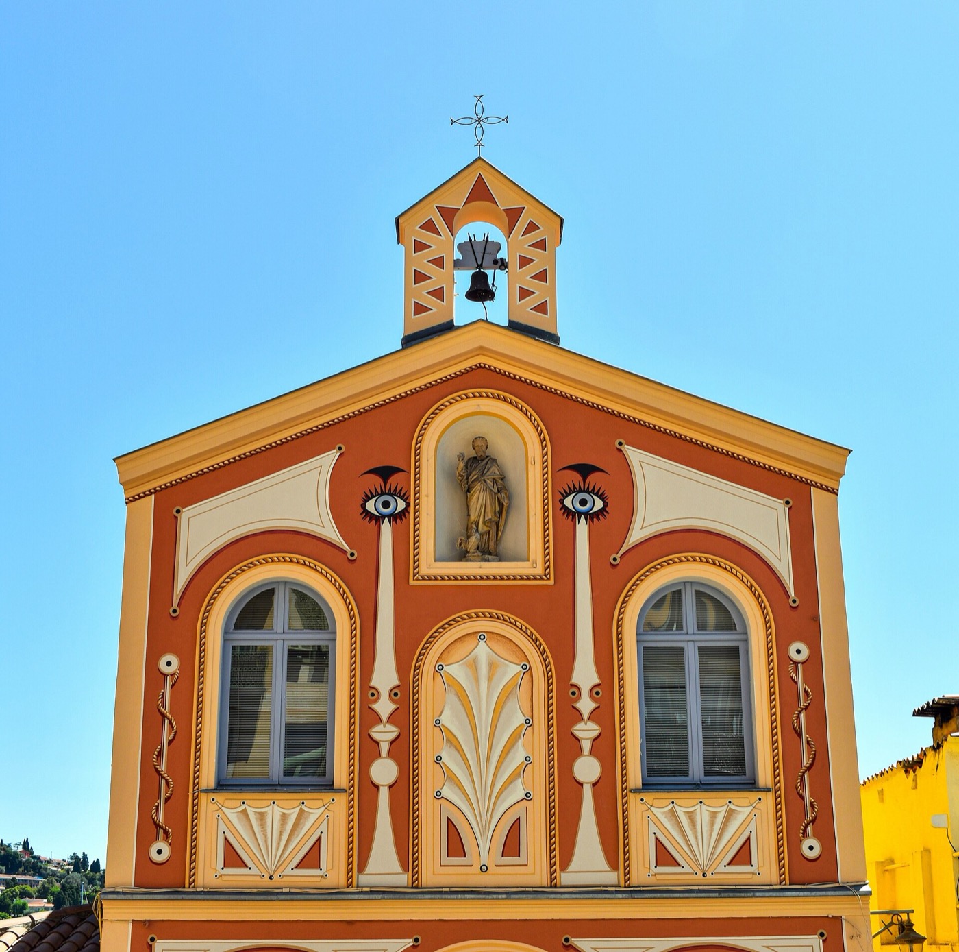 La façade orangée de la chapelle Saint-Pierre, avec son clocheton, sur le quai de Villefranche-sur-Mer