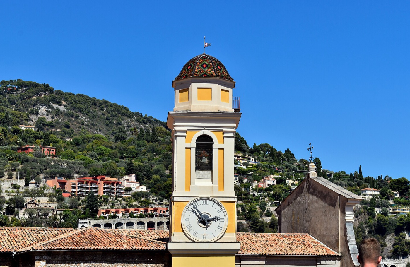 Le clocher jaune à cadran de l'église Saint-Michel de Villefranche-sur-Mer, au-dessus des toits